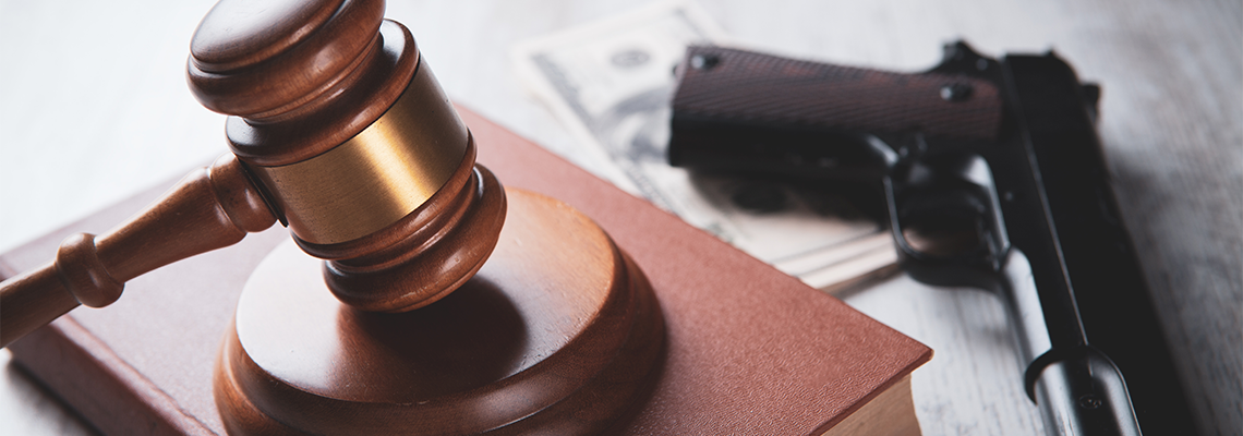 Court gavel with a gun on the table