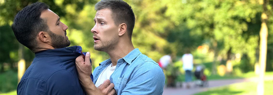 Angry man assaulting another man in park