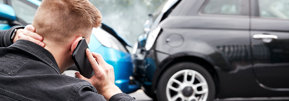 Young Male Motorist Involved In Car Accident Calling Insurance Company