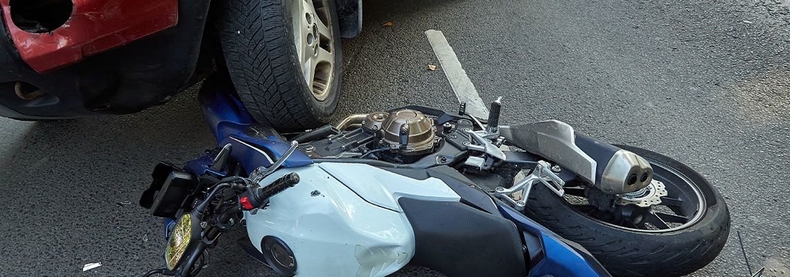 Motorcycle crash with car on road