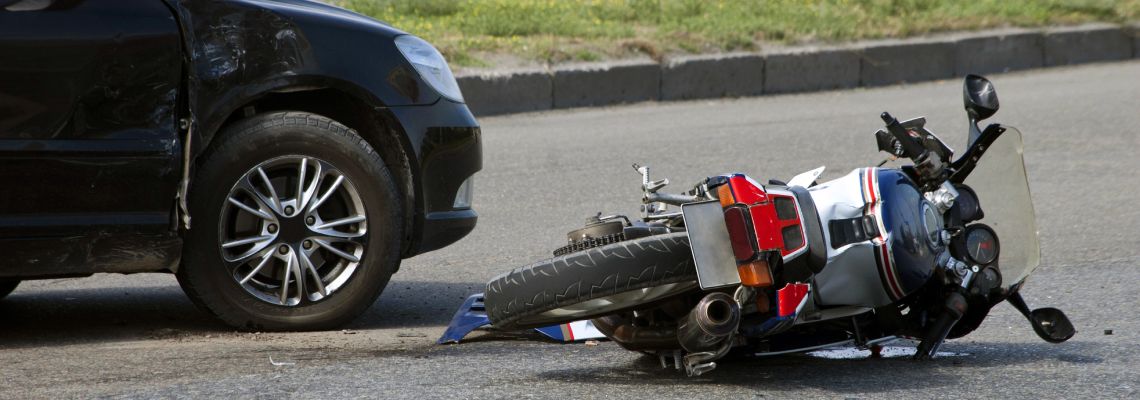 Motorcycle crash with car on road