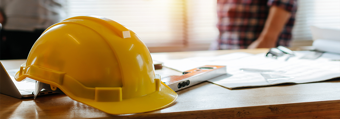 yellow safety helmet on workplace desk