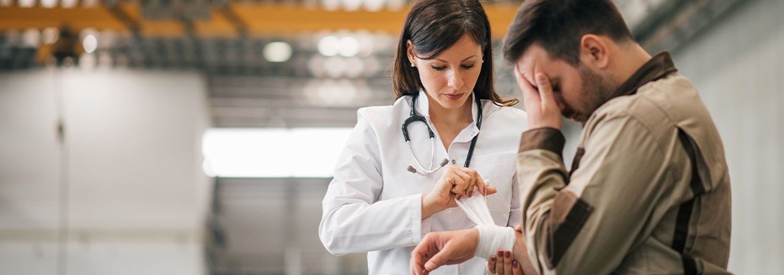 Injured worker being assisted by a female doctor
