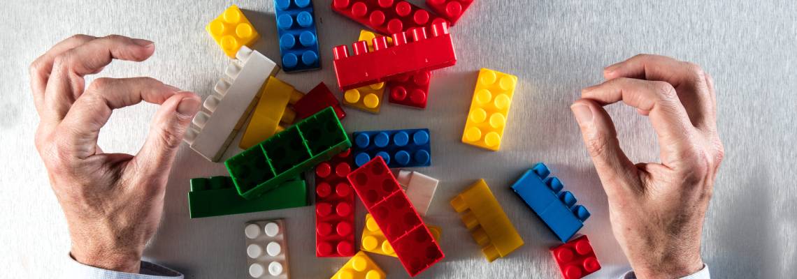 Businessman with Lego bricks, concept of restructuring