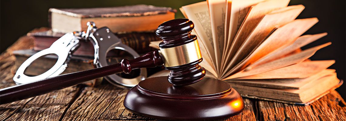 Wooden gavel , handcuff and books on wooden table