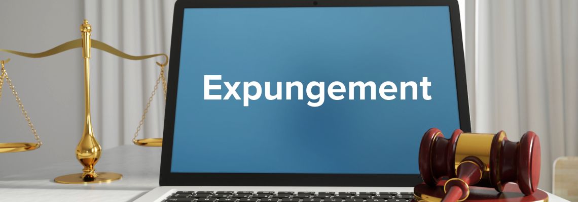 Laptop with term Expungement and gavel on table