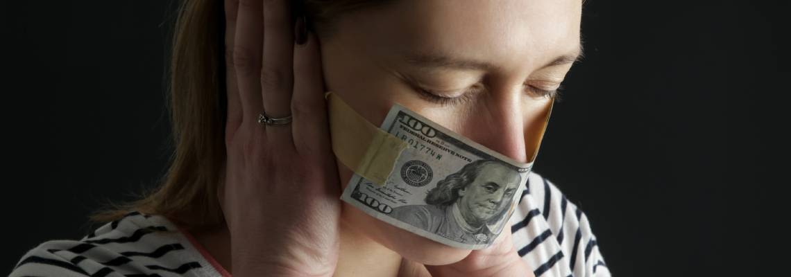 Woman's mouth covered with dollar bill