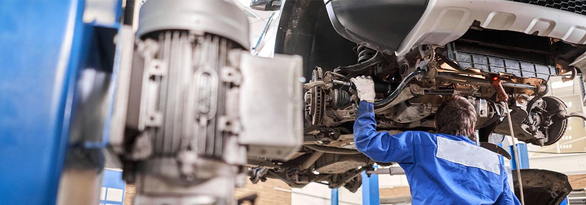 Mechanic inspecting damage in car