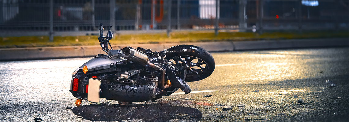 Motorcycle lying on asphalt after an road accident. Moto bike collision at night