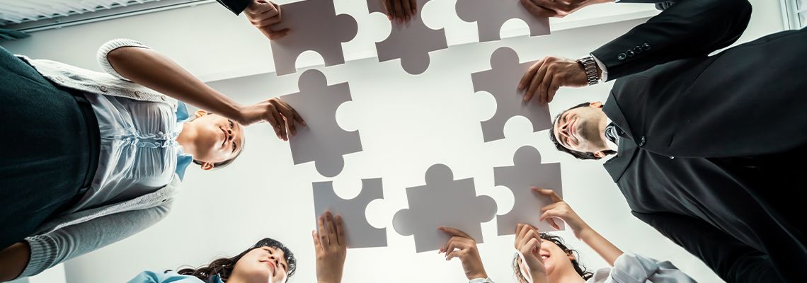 Business people holding jigsaw pieces, concept of business merger