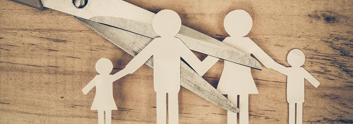 Scissors cutting paper cut of family