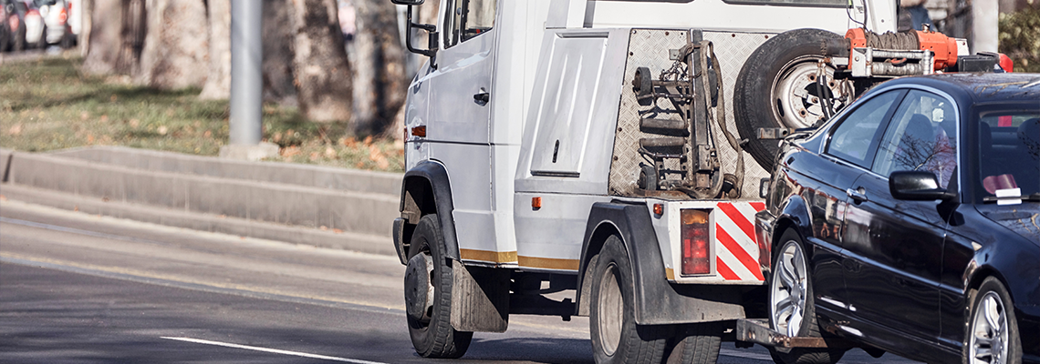 Tow truck carrying improperly parked car or repossesed vehicle