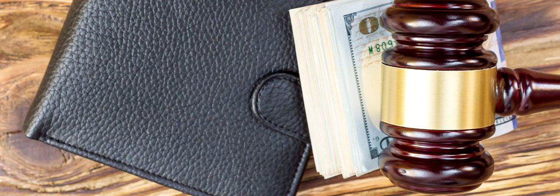 Gavel with folded dollars and wallet
