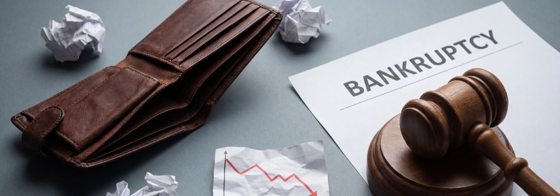 Empty wallet, declining chart and gavel on top of Bankruptcy file