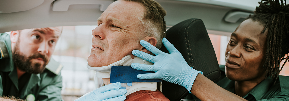 Paramedic placing a cervical collar to an injured man from car accident