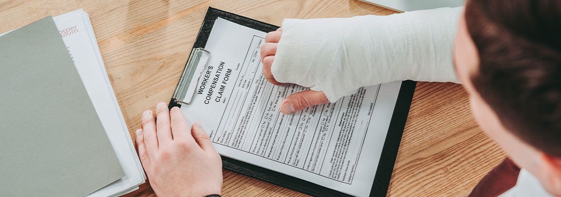 Man with injured hand filling for worker compensation