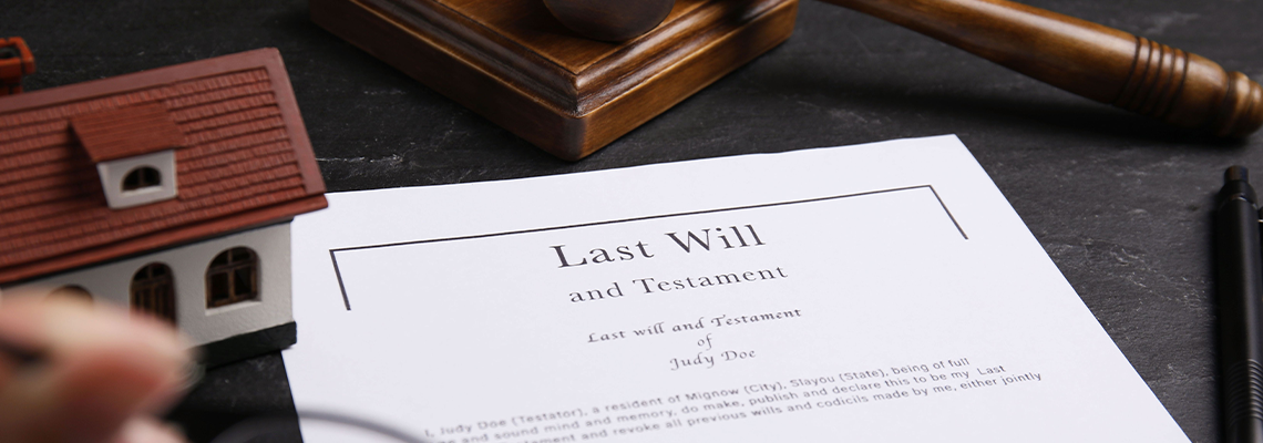 Last will and testament near house model, gavel on black table