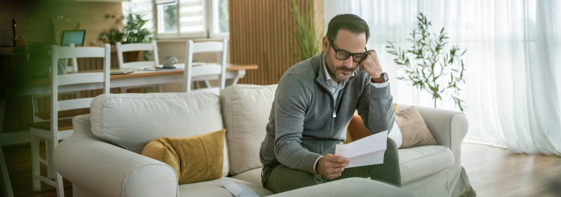 Man reading legal document at home