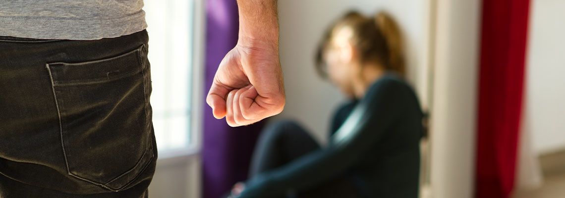 Man with closed fist and crying women in background