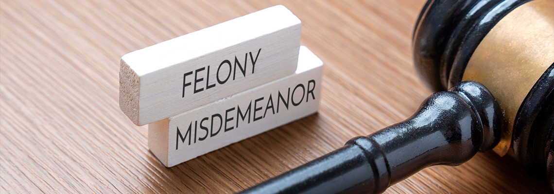 A judge’s gavel next to wooden blocks labeled Felony and Misdemeanor