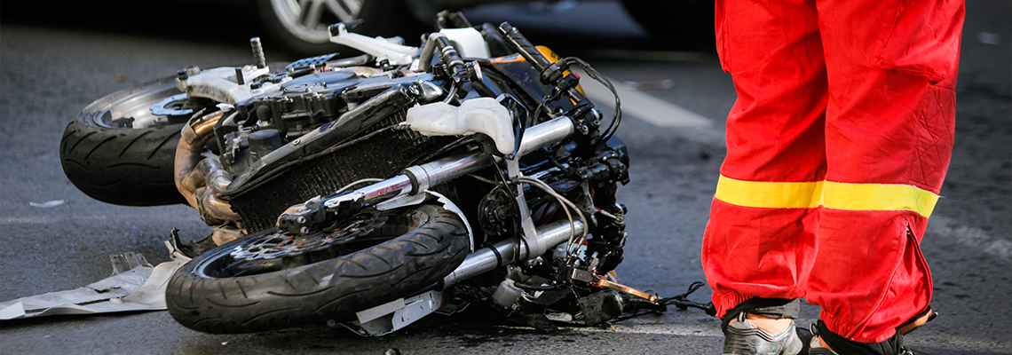 Crashed motorcycle after road accident with a car.