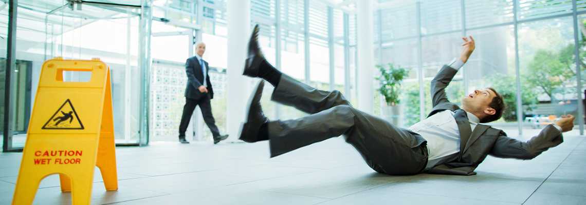 Businessman slipping on floor of office building
