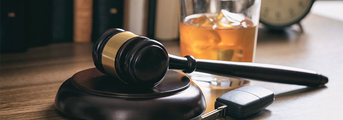 Gavel with car keys and glass of alcohol