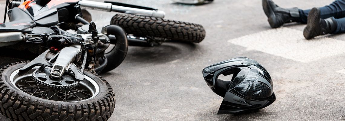 Helmet, Motorcycle and rider on road after accident