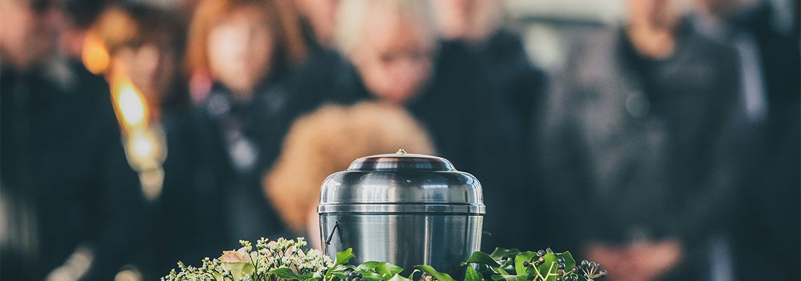 Metal Urn and mourning family members in background