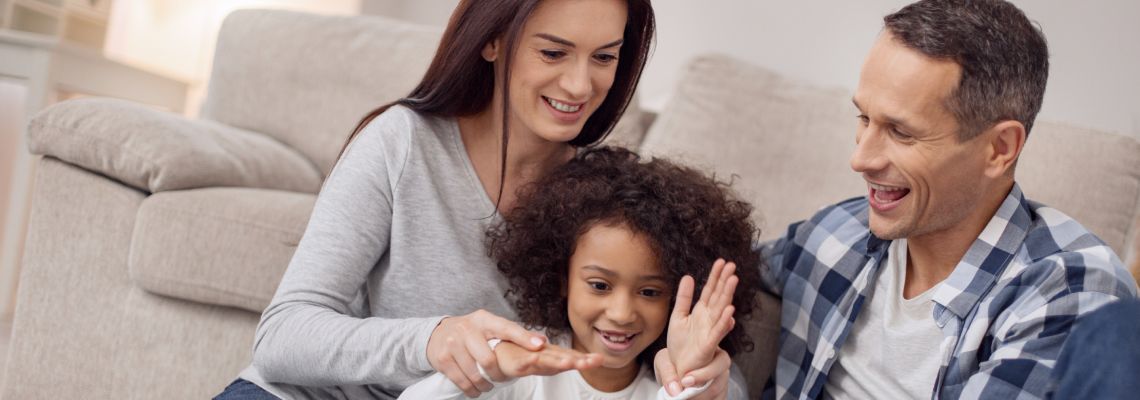 Adopted little girl having fun with her parents at home