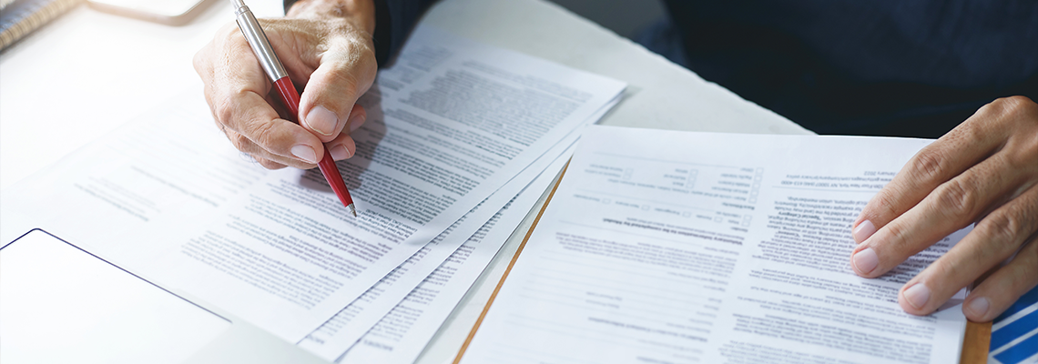 Asian businessman reviewing document reports at office workplace