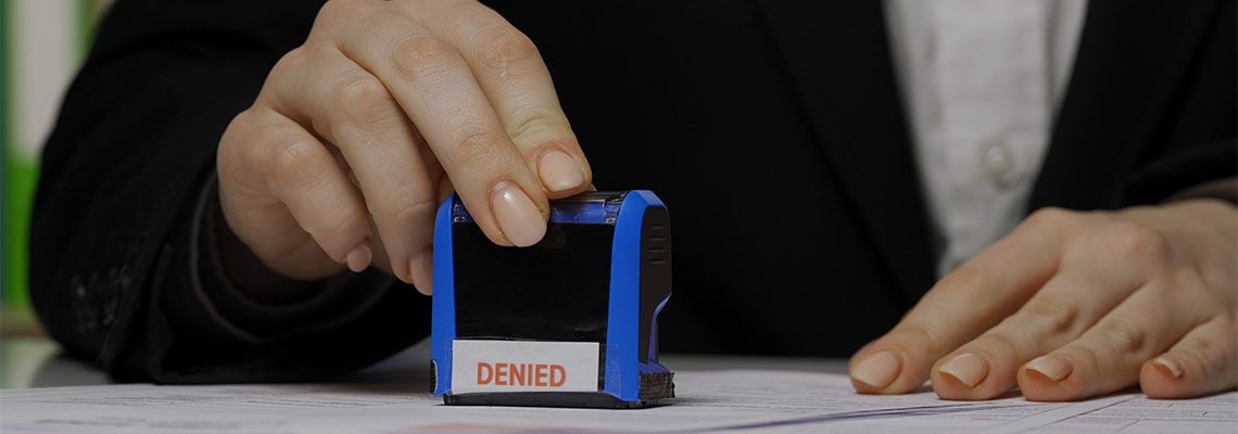 Women putting denied stamp on visa application