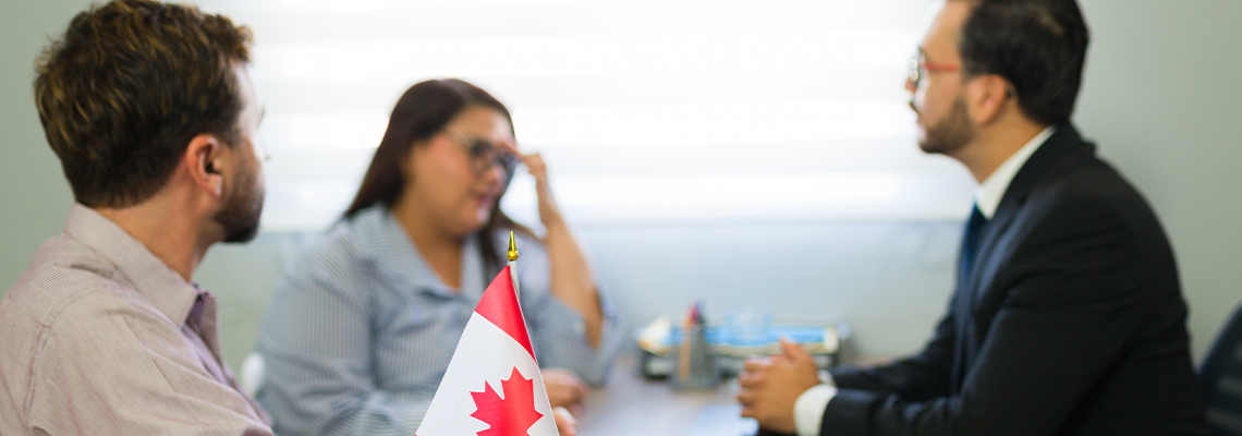 Couple discussing canadian immigration with lawyer in office