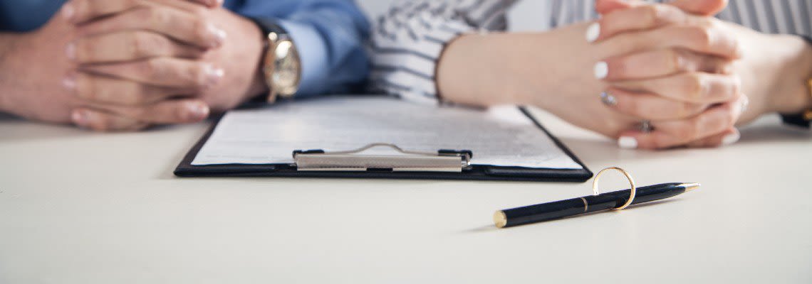 Man and a woman sitting with divorce papers in front of them