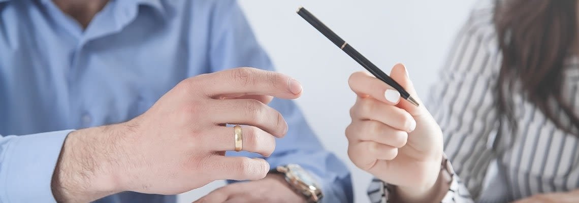 Woman handing a man a pen working on divorce documents