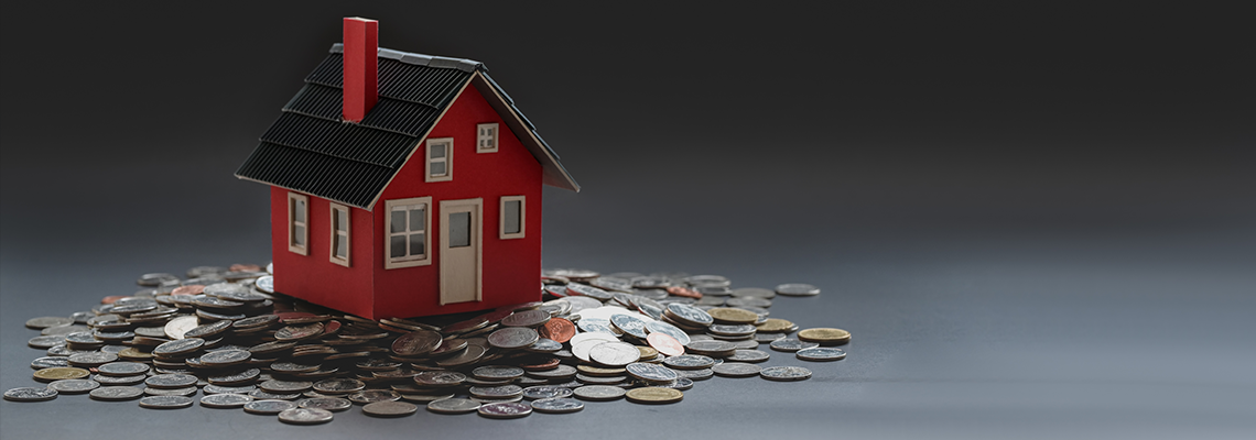 Small model house on stack of american coins