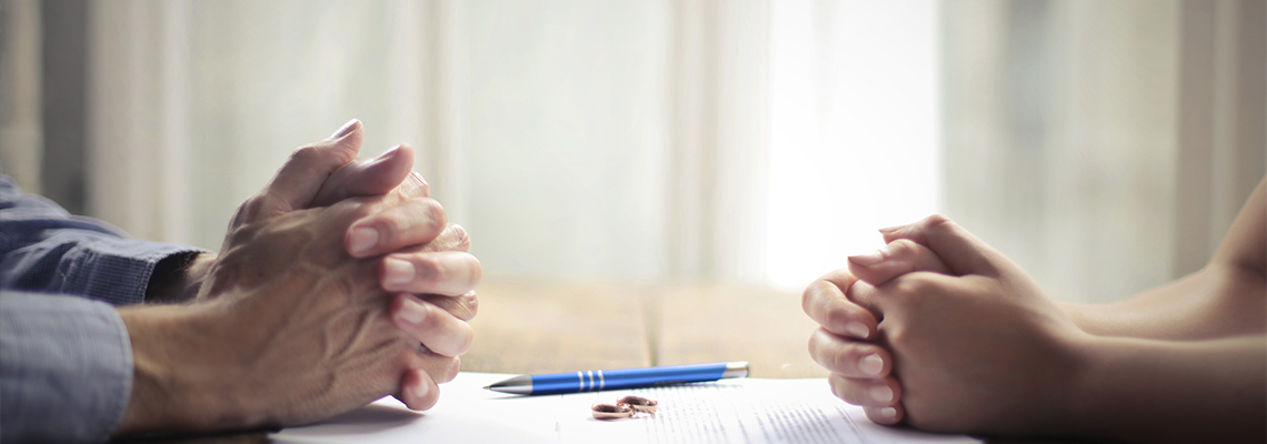 Paper, Rings and Pen in between a couple's separate hands