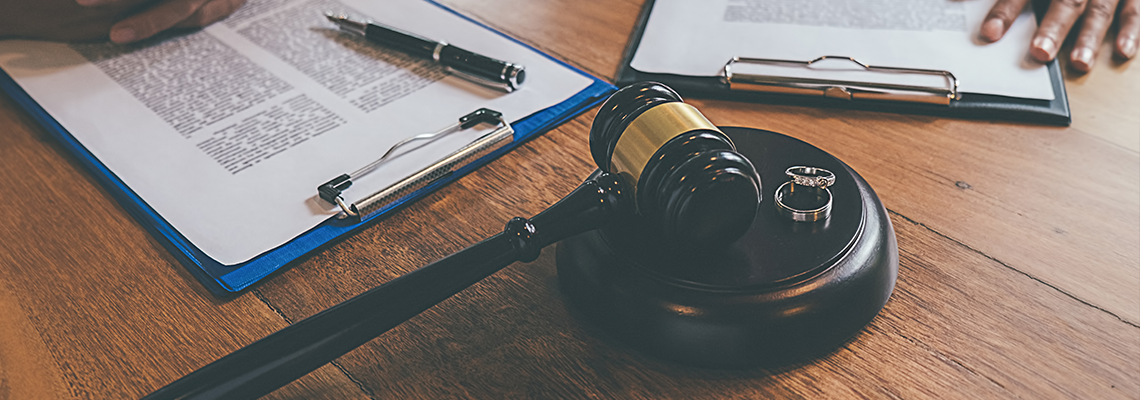 Judge gavel with Justice lawyers deciding, marriage divorce between married couple and signing divorce documents on table.