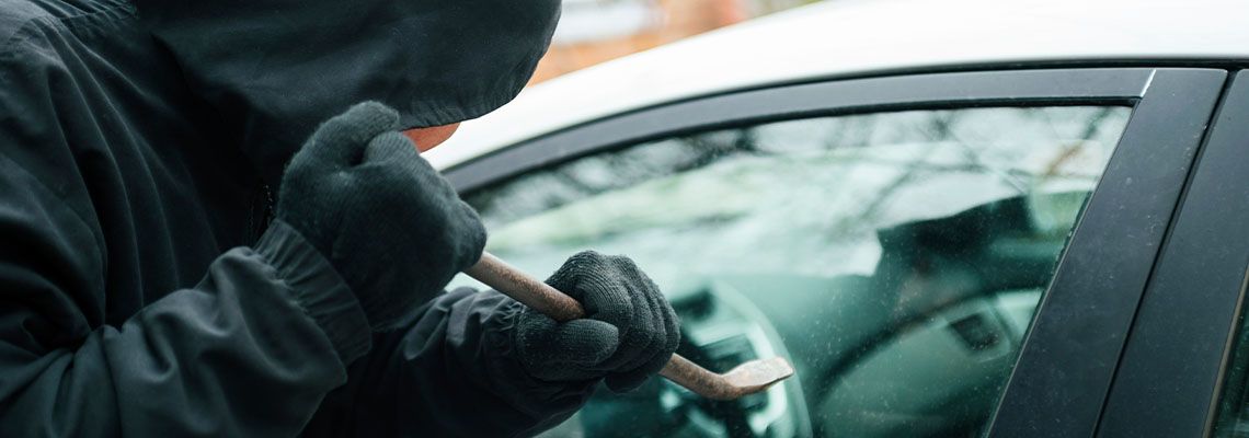 Thief breaking into a car