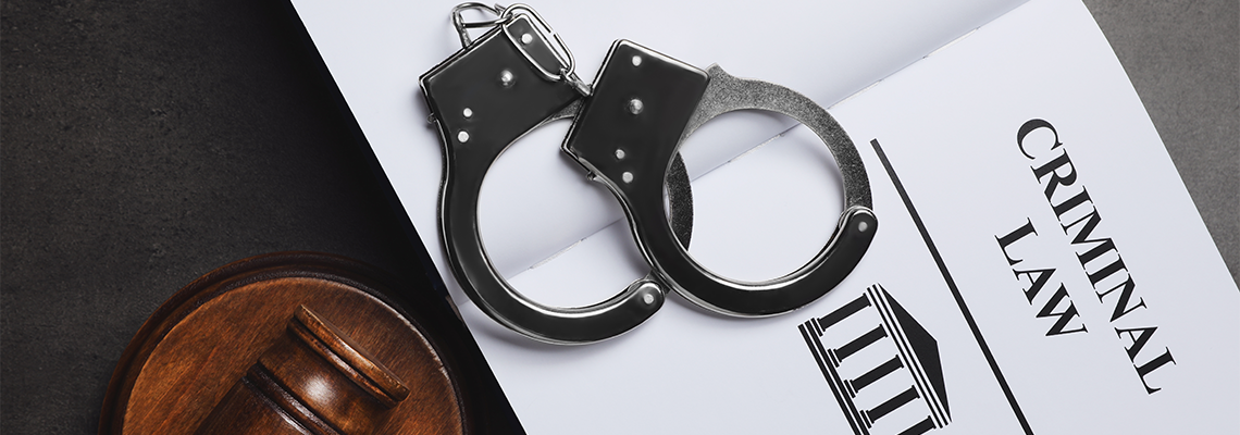Judge's gavel, handcuffs and Criminal law book on grey background