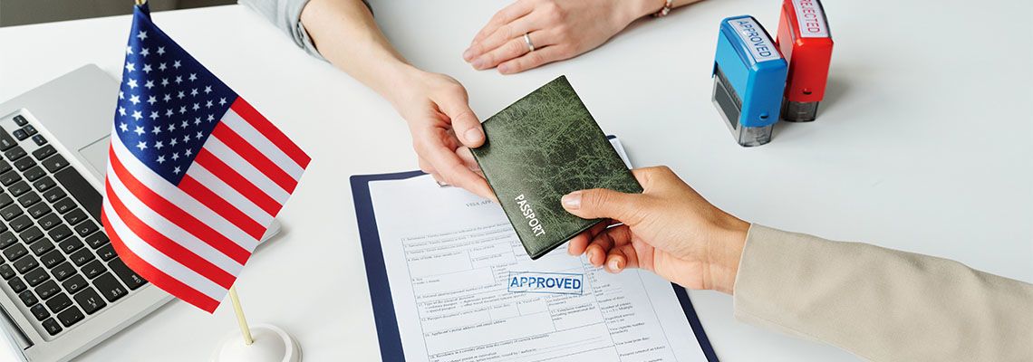 Approved stamp on document and women handing passport to visa consular