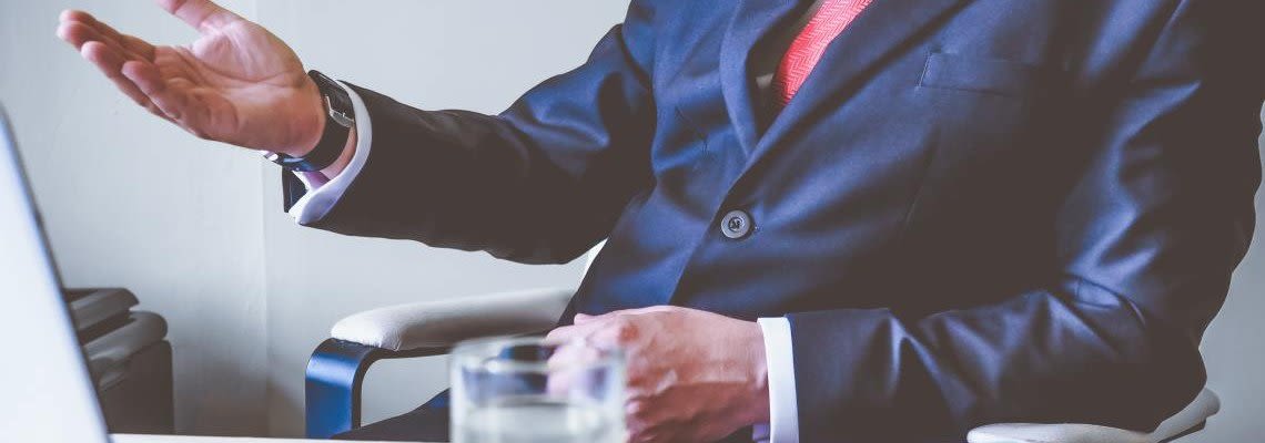 Attorney speaking with hand gestures while sitting at a desk