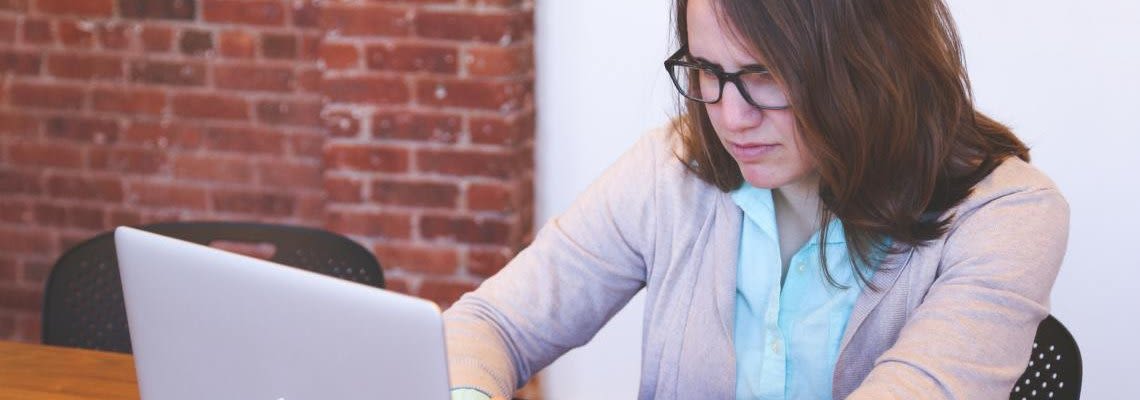 Woman staring intently while working on a laptop