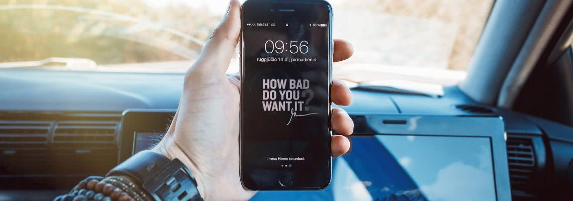 Hand holding a phone while in the car
