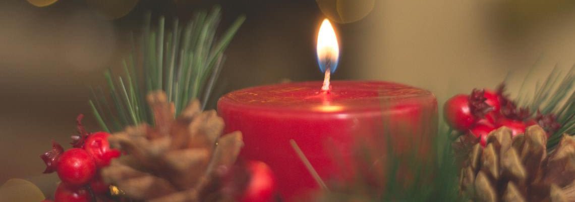 Holiday-themed candle with pine cones