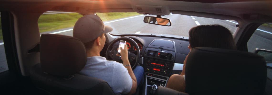 Man and woman in car driving down the road
