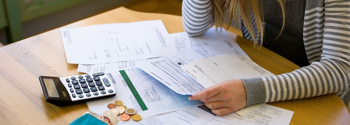 Woman cradling her head with bankruptcy documents spread in front of her