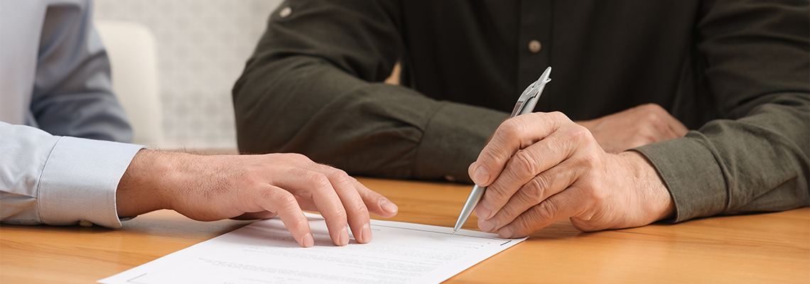Notary showing senior man where to sign Last Will and Testament