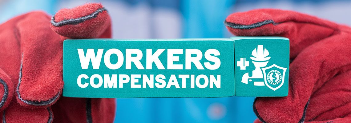 Worker holding a block with inscription WORKERS COMPENSATION