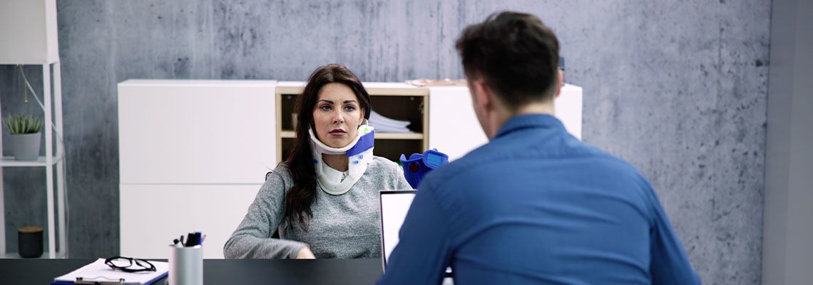 Woman with neck injury meeting with workers comp attorney